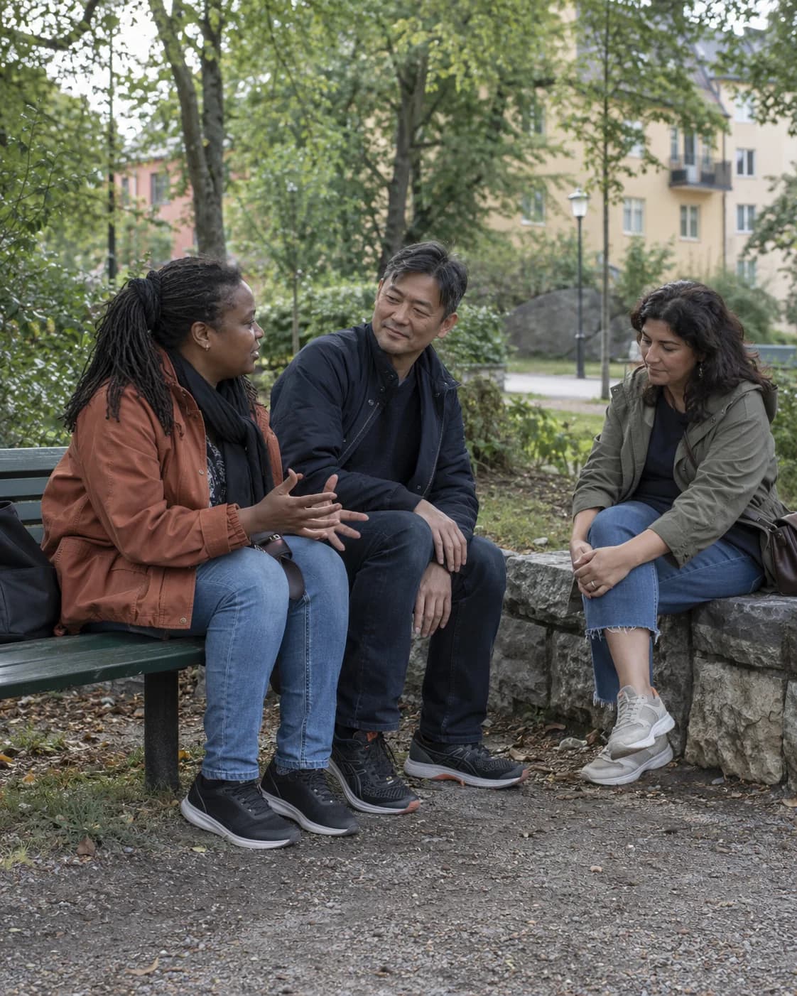 Tre vänner samtalar i en grönskande park